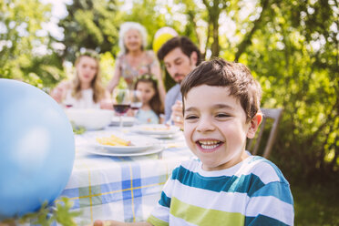 Glücklicher Junge auf einer Gartenparty mit seiner Familie in Bakground - MFF001263