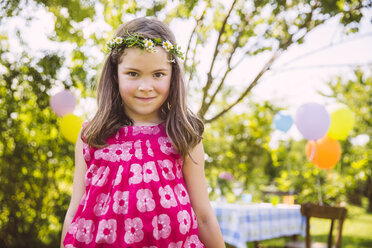 Porträt eines Mädchens, das vor seinem Geburtstagstisch im Garten steht - MFF001271