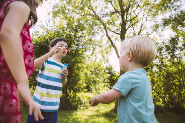 Kinder blasen Seifenblasen im Garten - MFF001277