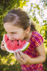 Mädchen isst ein Stück Wassermelone im Garten - MFF001282
