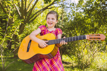 Mädchen spielt Gitarre im Garten - MFF001302