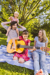 Familie auf Picknickdecke spielt Gitarre - MFF001306