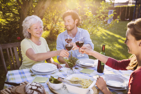 Ehepaar und ältere Frau beim Abendessen im Garten - MFF001308