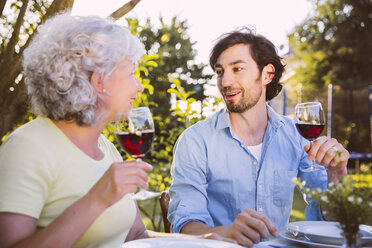 Mann und ältere Frau beim Abendessen im Garten - MFF001309
