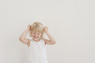 Porträt eines wütenden kleinen Jungen, der sich die Haare rauft - MJF001329