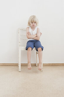 Porträt eines trotzigen kleinen Jungen mit verschränkten Armen - MJF001330