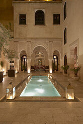 Marokko, Fes, Hotel Riad Fes, Innenhof mit beleuchtetem Pool bei Nacht - KMF001429