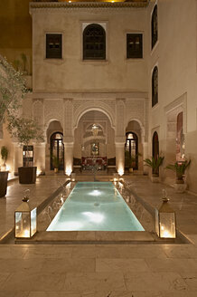 Marokko, Fes, Hotel Riad Fes, Innenhof mit beleuchtetem Pool bei Nacht - KMF001429