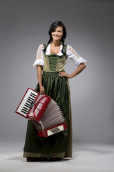 Portrait of young woman with accordion wearing dirndl - MAEF009040