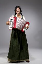 Portrait of young woman with accordion wearing dirndl - MAEF009042