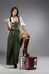 Portrait of young woman with accordion wearing dirndl - MAEF009044