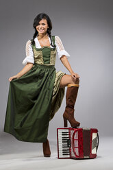 Portrait of young woman with accordion wearing dirndl - MAEF009045