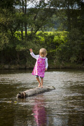 Little girl balancing on a rock in a river - LVF001802