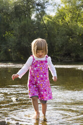 Little girl walking in water at riverside - LVF001804