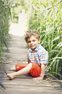 Porträt eines kleinen Jungen auf dem Gehweg sitzend - AFF000071