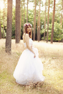 Braut in weißem Hochzeitskleid und Blumen auf einer Wiese - AFF000076