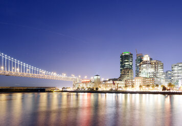 USA, California, San Francisco, Oakland Bay Bridge and Rincon Park at night - BRF000703