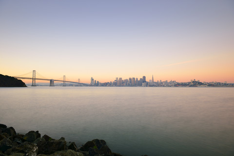 USA, Kalifornien, San Francisco, Oakland Bay Bridge und Skyline des Financial District im Morgenlicht, lizenzfreies Stockfoto