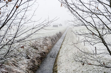 Austria, Salzburg State, Radstadt, brook through scnow-capped meadows - HHF004884