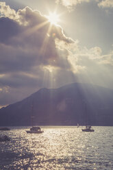 Italien, Venetien, Brenzone, Segelboote auf dem Gardasee im Gegenlicht der Sonne - LVF001818