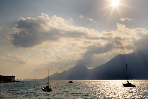 Italien, Venetien, Brenzone, Segelboote auf dem Gardasee im Gegenlicht der Sonne - LVF001858