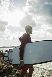 France, Brittany, Camaret-sur-Mer, teenage boy with surfboard at the ocean - UUF001655