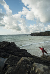 Frankreich, Bretagne, Camaret-sur-Mer, Jugendlicher mit Surfbrett am Meer - UUF001656