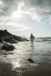 France, Brittany, Camaret-sur-Mer, teenage boy with surfboard at the ocean - UUF001657