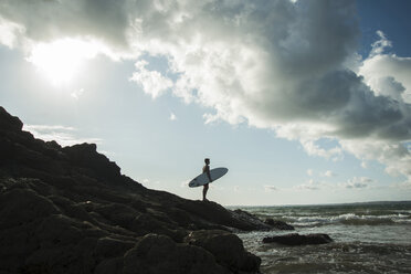 Frankreich, Bretagne, Camaret-sur-Mer, Jugendlicher mit Surfbrett am Meer - UUF001660