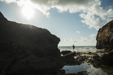 Frankreich, Bretagne, Camaret-sur-Mer, Jugendlicher mit Surfbrett am Meer - UUF001662