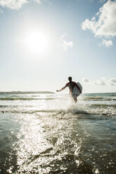 Frankreich, Bretagne, Camaret-sur-Mer, Jugendlicher mit Surfbrett am Meer - UUF001665