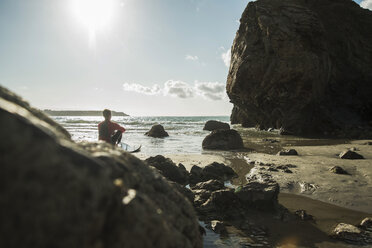 Frankreich, Bretagne, Camaret-sur-Mer, Jugendlicher mit Surfbrett am Meer - UUF001668