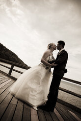 Bridal couple kissing in front of the Baltic Sea - MABF000237