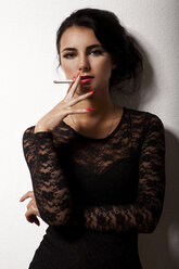 Porträt einer rauchenden jungen Frau mit rotem Nagellack - JUNF000034
