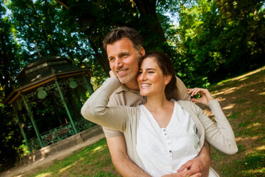 Happy couple standing in the park - CHAF000144