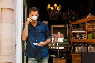 Portrait of man drinking coffee at coffee shop - CHAF000179