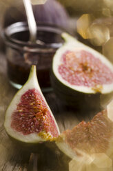 Sliced fig and glass of fig jam om wooden table - ODF000822