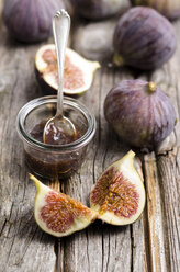 Figs and a glass of fig jam on a wooden table - ODF000825