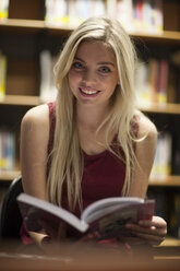 Studentin beim Lesen eines Buches in einer Bibliothek - ZEF000826