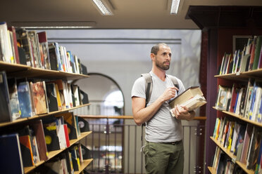 Student in einer Bibliothek am Bücherregal - ZEF000833