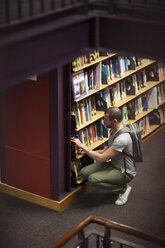 Student in einer Bibliothek am Bücherregal - ZEF000835