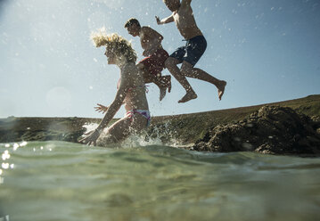 Drei Teenager springen ins Meer - UUF001681