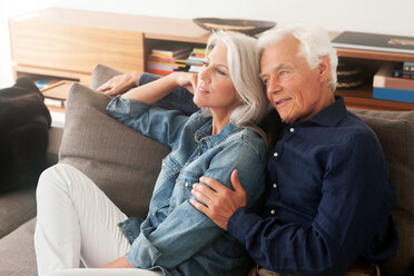 Porträt eines liebenden älteren Paares, das Seite an Seite auf der Couch sitzt - CHAF000163