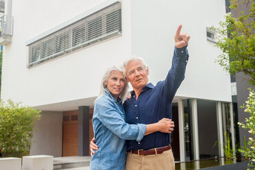 Portrait of senior couple standing together watching something - CHAF000175