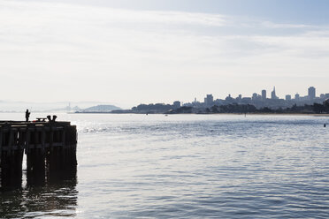 USA, California, San Francisco, angler on pier, skyline in the background - FOF007053