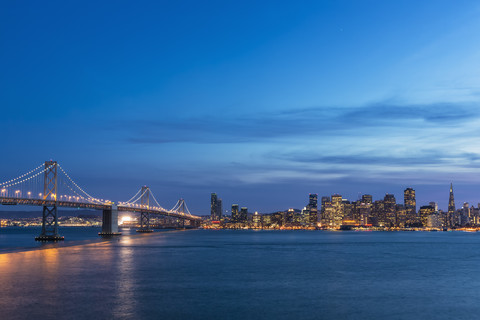 USA, Kalifornien, San Francisco, Skyline und Oakland Bay Bridge am Abend, lizenzfreies Stockfoto