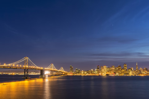 USA, Kalifornien, San Francisco, Skyline und Oakland Bay Bridge am Abend, lizenzfreies Stockfoto