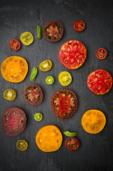 Slices of different heirloom tomatoes on slate - LVF001861