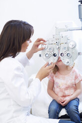 Eye doctor examining girl's vision - ZEF000598