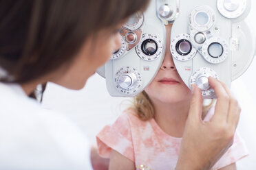 Eye doctor examining girl's vision - ZEF000599